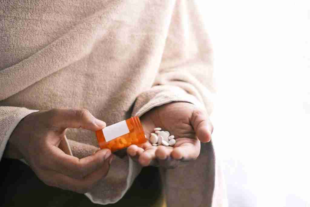 counseling_therapy A person contemplating between depression therapy and medication while holding a bottle of pills.